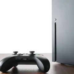 Czarny kontroler Xbox i konsola Series X na drewnianym blacie. Czy gry z Xbox 360 działają na Xbox Series X? Sprawdźmy!