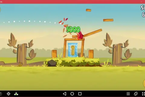 Gra Angry Birds na emulatorze. Czerwony ptak niszczy konstrukcję, zdobywając 5000 punktów.