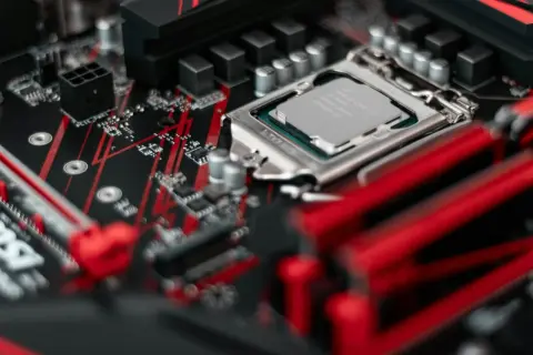 Zbliżenie na procesor Intel Core i5 zamontowany na czerwono-czarnej płycie głównej.