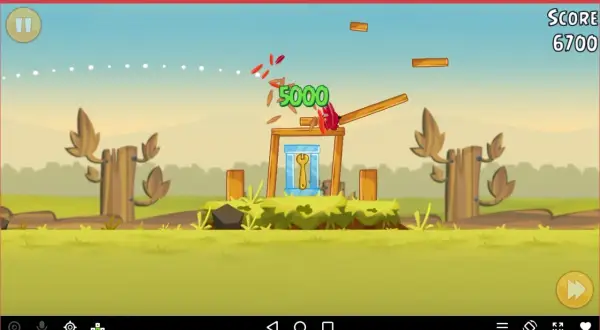 Gra Angry Birds na emulatorze. Czerwony ptak niszczy konstrukcję, zdobywając 5000 punktów.