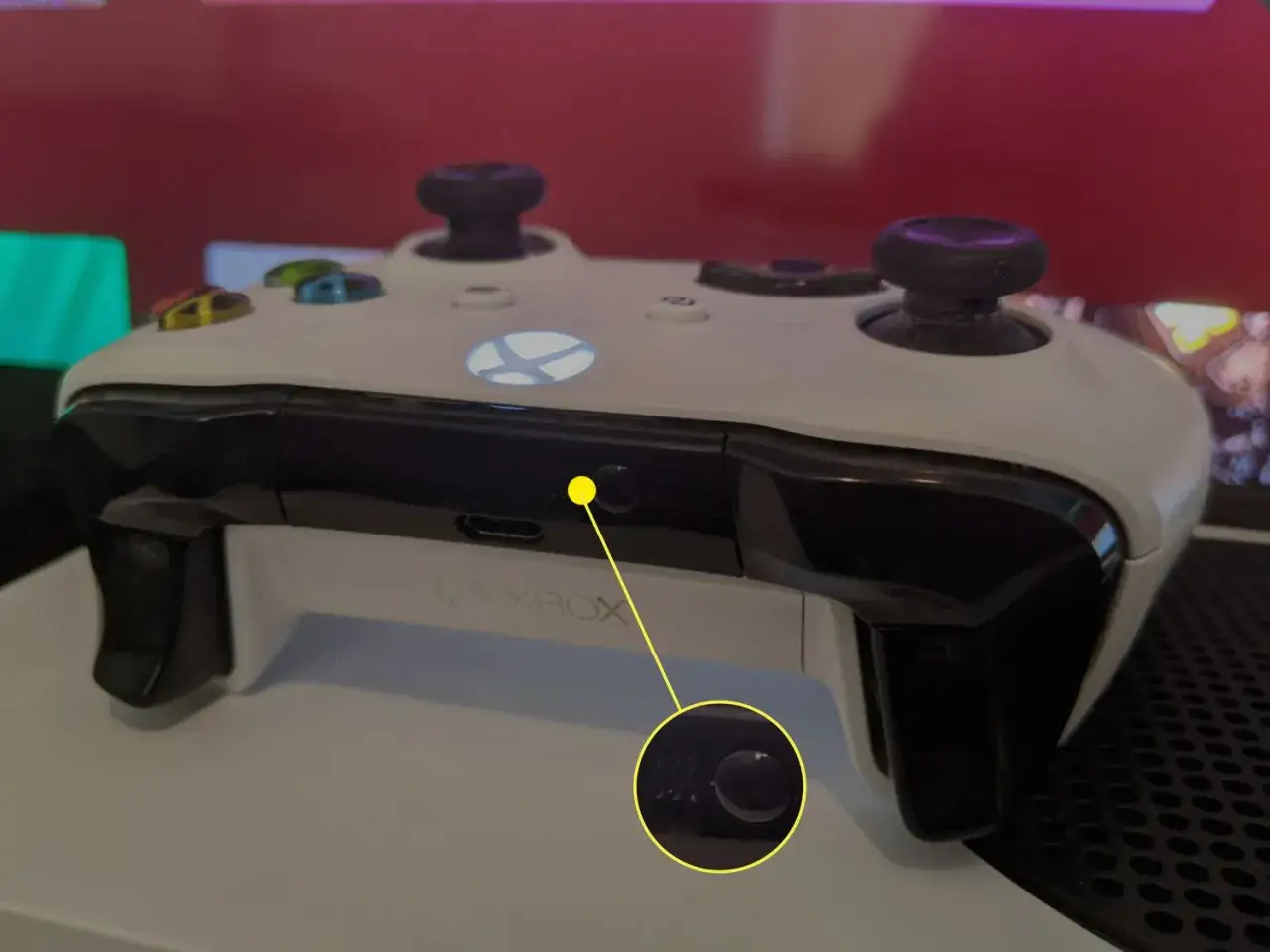 Biały kontroler Xbox One, z żółtą strzałką wskazującą przycisk parowania Xbox One.