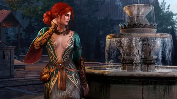 Triss Merigold w alternatywnym wyglądzie, w bogato zdobionej sukni, stoi obok kamiennej fontanny.